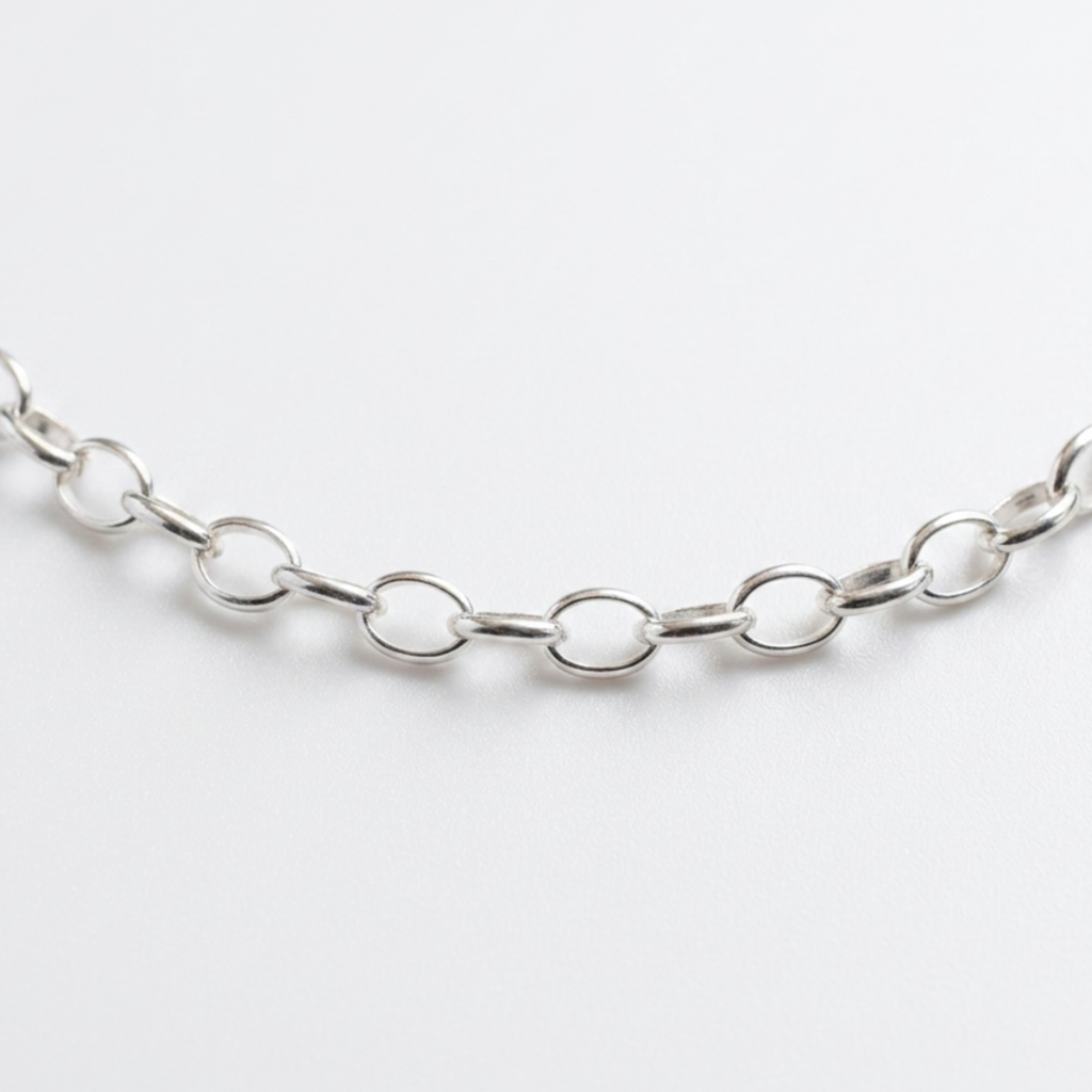 Freigestellte Nahaufnahme einer Gliederkette im Rolo-Stil (Ankerkette) aus hochglanzpoliertem 925er Silber auf weißem Hintergrund.