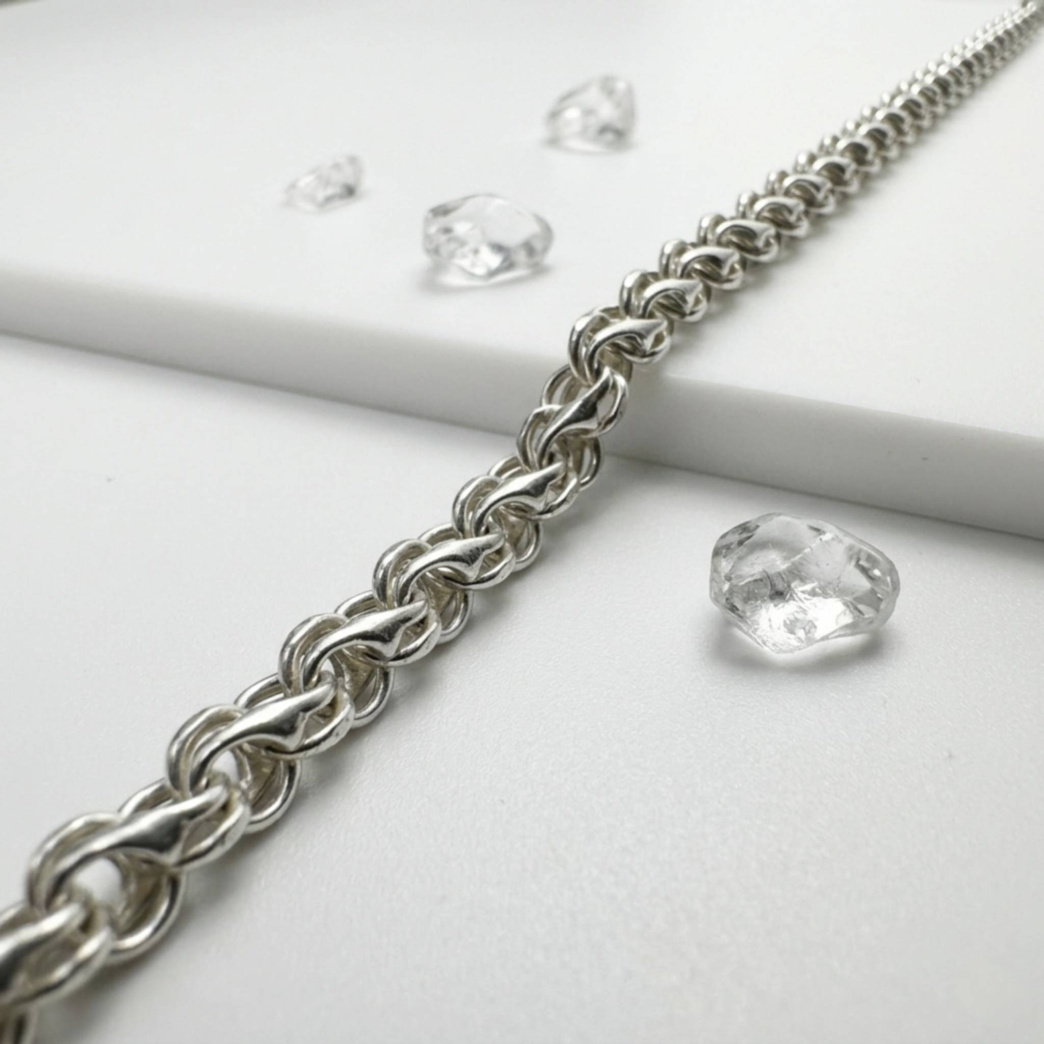 Handgefertigte der eleganten Unisexkette Modell Bismarck-Bach aus 925er Sterling Silber zur Demonstration des plastischen Geflechts auf hellem Untergrund mit transparenten Steinen.