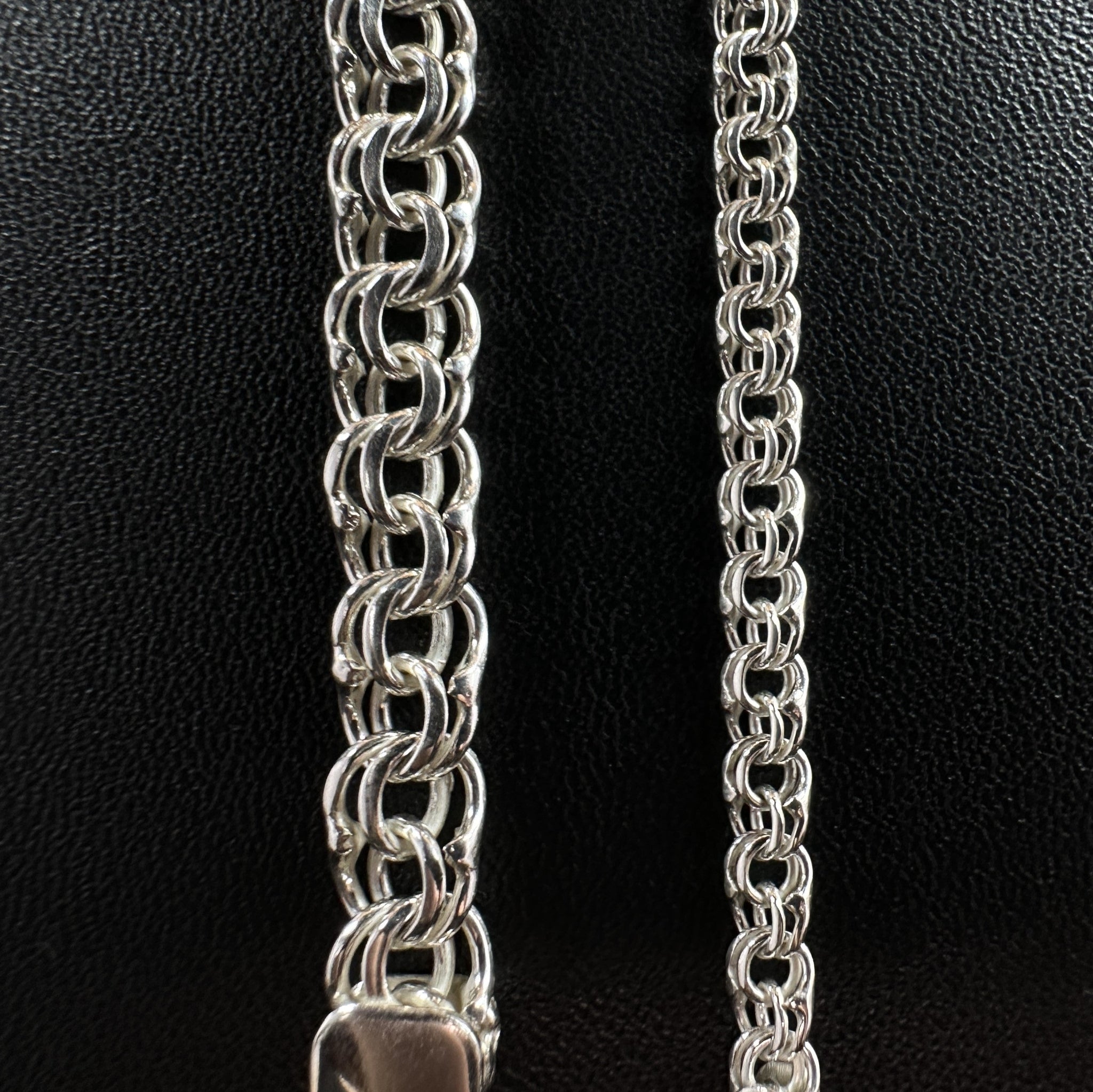Größenvergleich zweier handgefertigter Silberketten Modell Python aus 925er Silber auf schwarzem Leder mit einer massiven 30 Gramm Kette links und einer feineren 10 Gramm Kette rechts.
