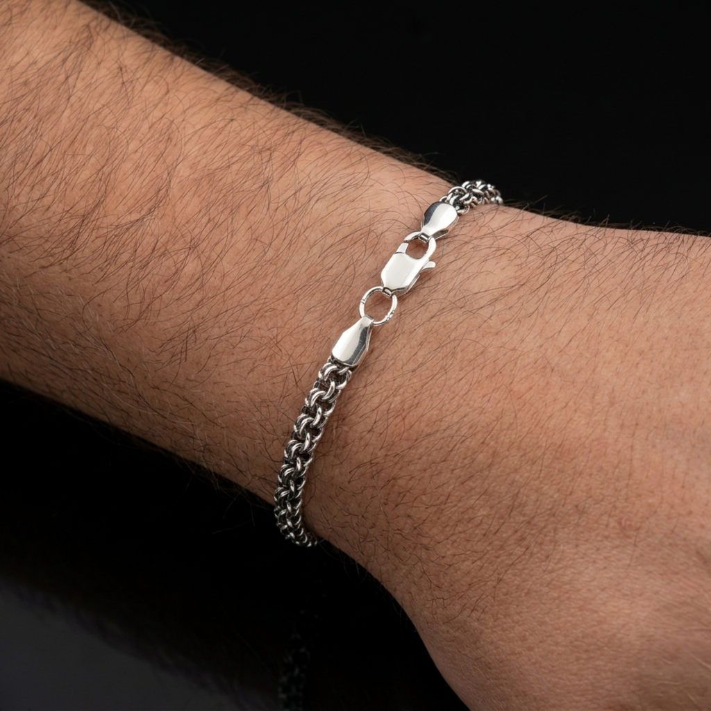 Exklusives handgefertigtes Herrenarmband „Bismarck Rund“ aus 925er Silber mit oxidierter Oberfläche am Handgelenk. Zeigt das massive Geflecht und den robusten Karabinerverschluss in Nahaufnahme.