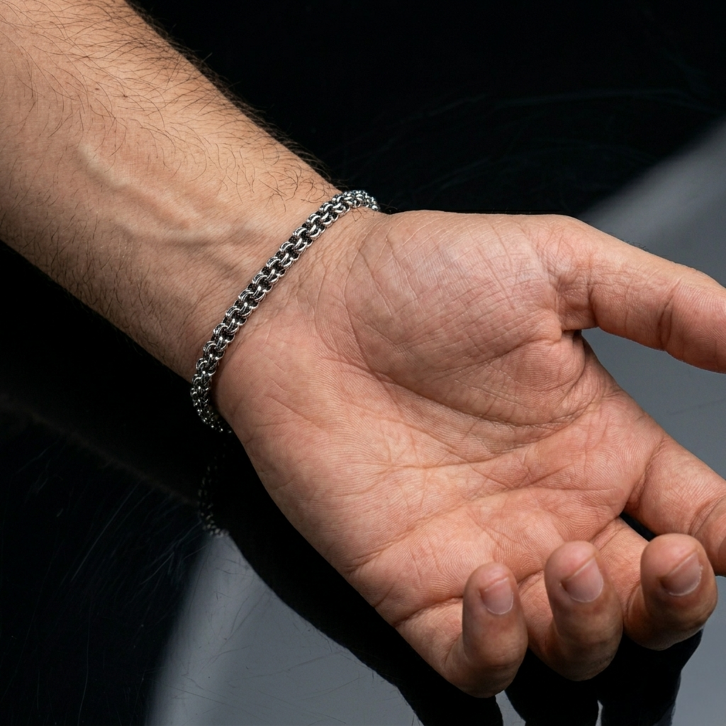 Tragebeispiel des handgefertigten Silberarmbands Modell „Bismarck Rund“ (925er Silber, oxidiert) am behaarten Herrenhandgelenk. Der Karabinerverschluss aus 925er Silber ist gut sichtbar.