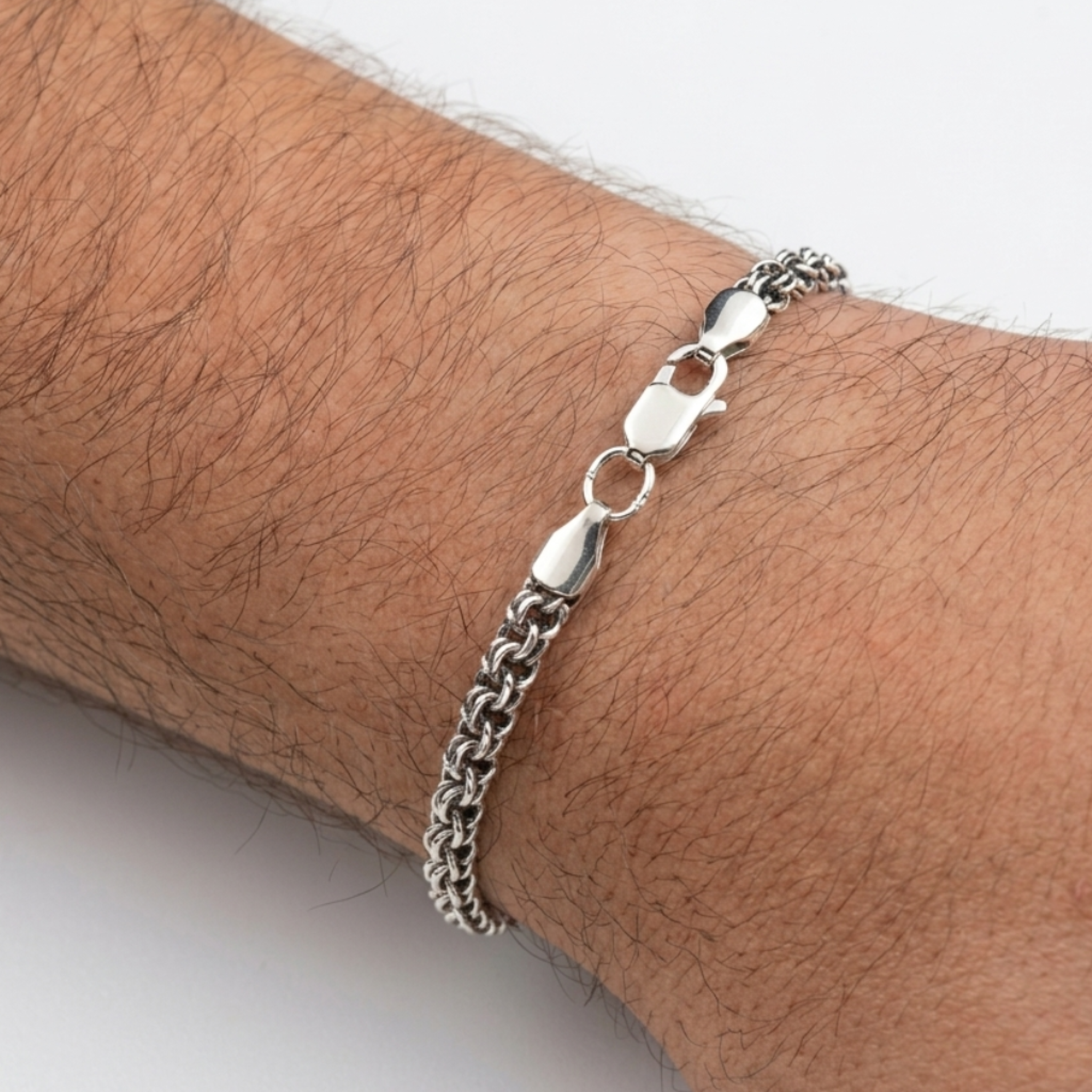 Tragebeispiel des handgefertigten Silberarmbands „Bismarck Rund“ (925er Silber, oxidiert) mit sichtbarem Karabinerverschluss vor hellem Hintergrund.