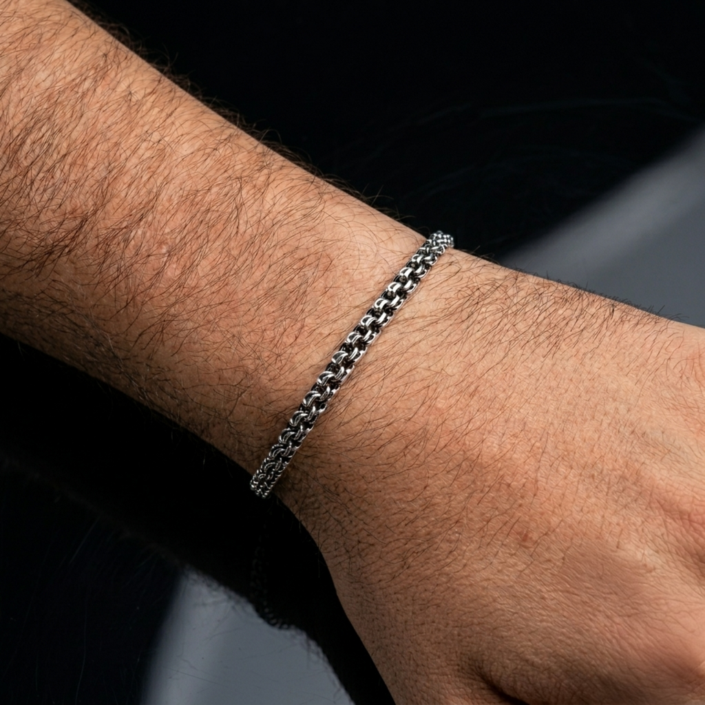 Silberarmband „Bismarck Rund“ (Handarbeit, 925er Silber, oxidiert) am Handgelenk, Detailaufnahme.
