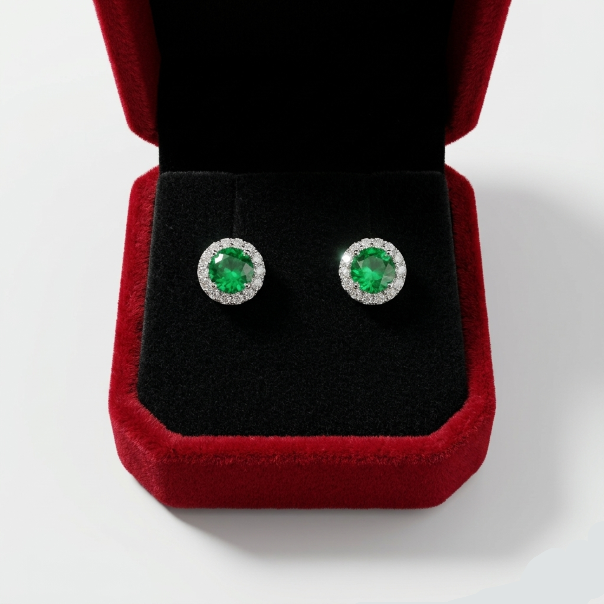 Ein Paar 925 Sterling Silber Halo-Ohrstecker rhodiniert mit grünem Zirkonia-Stein und Schraubverschluss in einer roten Samt-Schmuckbox.