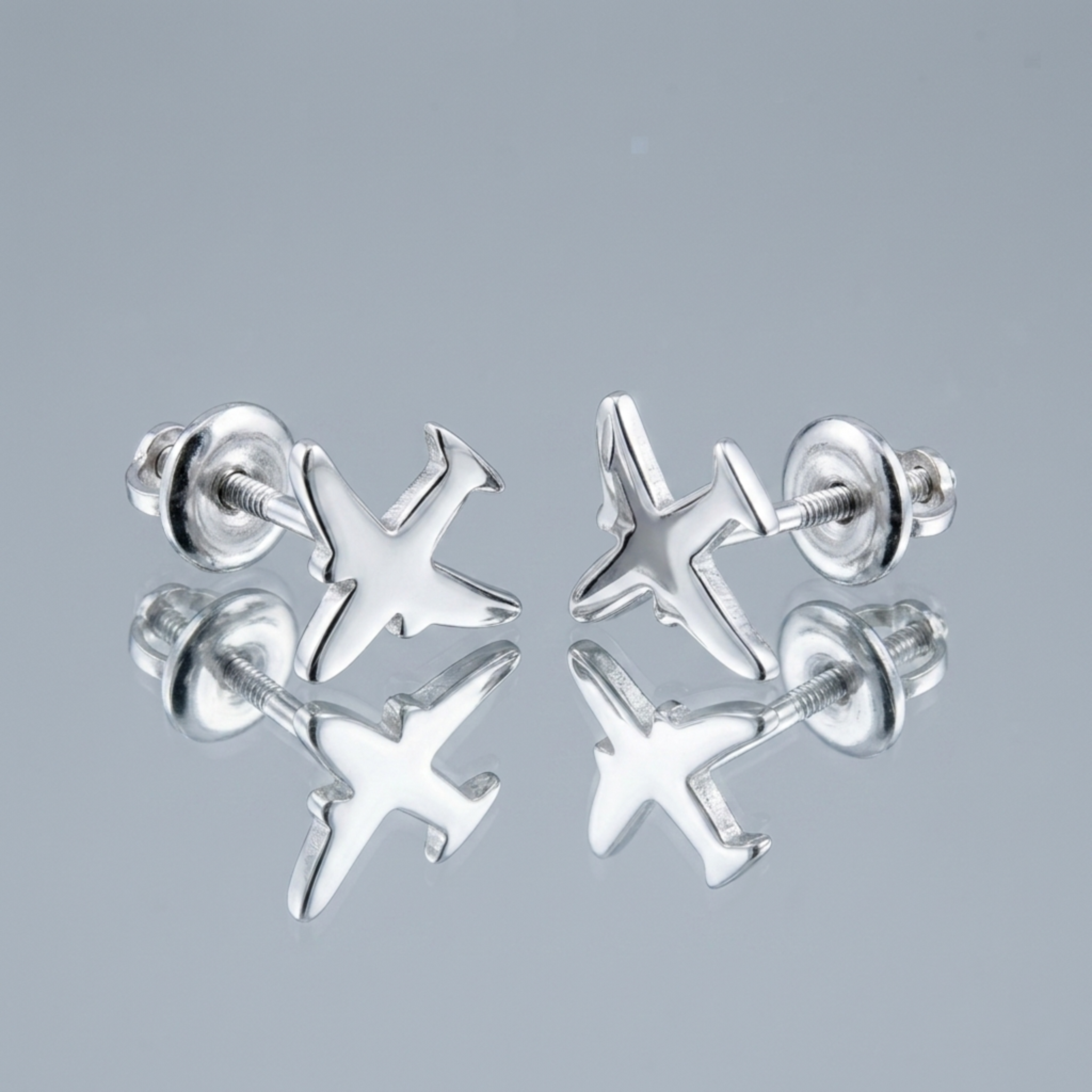 Handgefertigte Silber-Ohrstecker „Flugzeug“ aus 925 Sterling Silber rhodiniert mit Schraubverschluss auf einer Spiegeloberfläche.