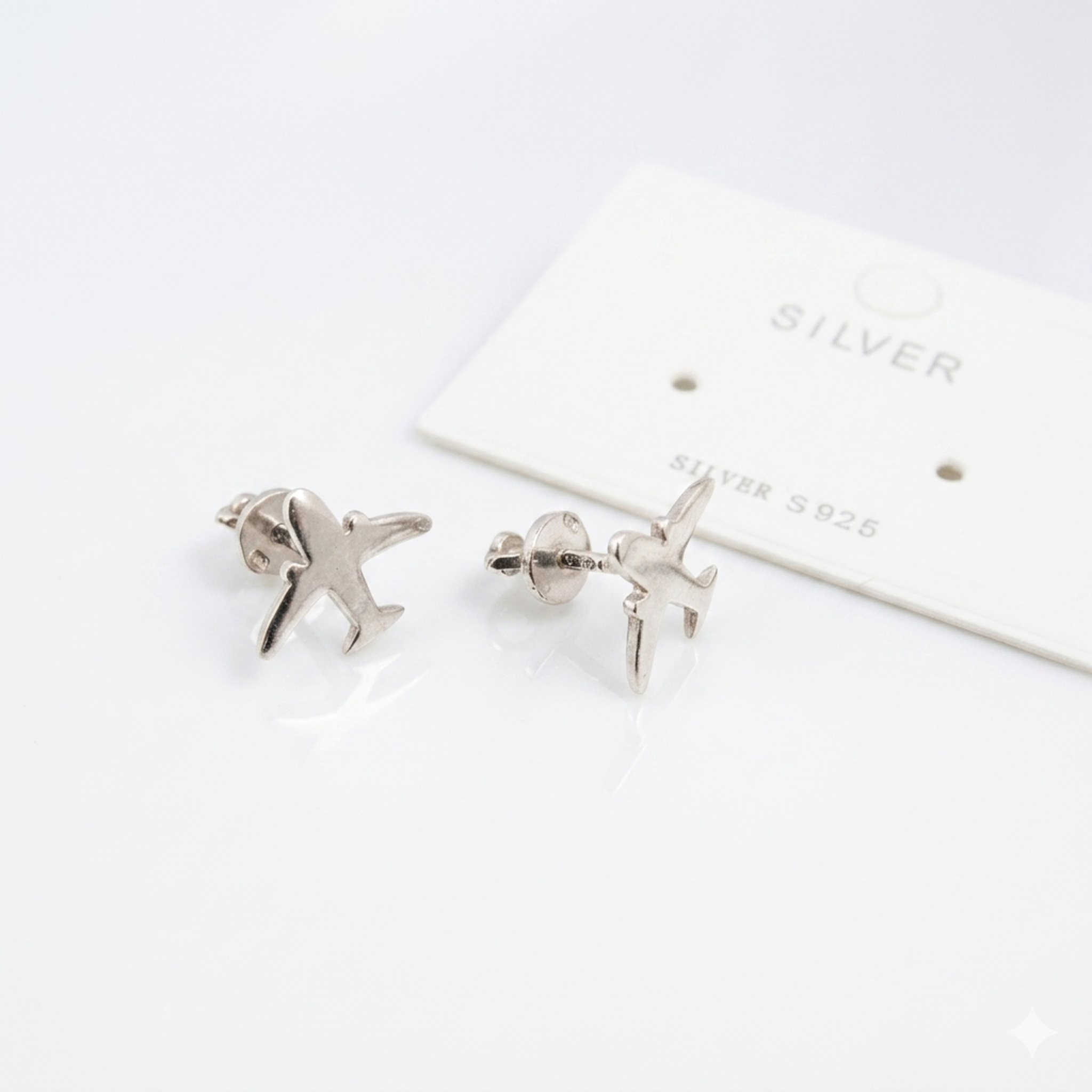 Handgefertigte Silber-Ohrstecker „Flugzeug“ aus 925 Sterling Silber rhodiniert mit Schraubverschluss auf weißem Hintergrund.
