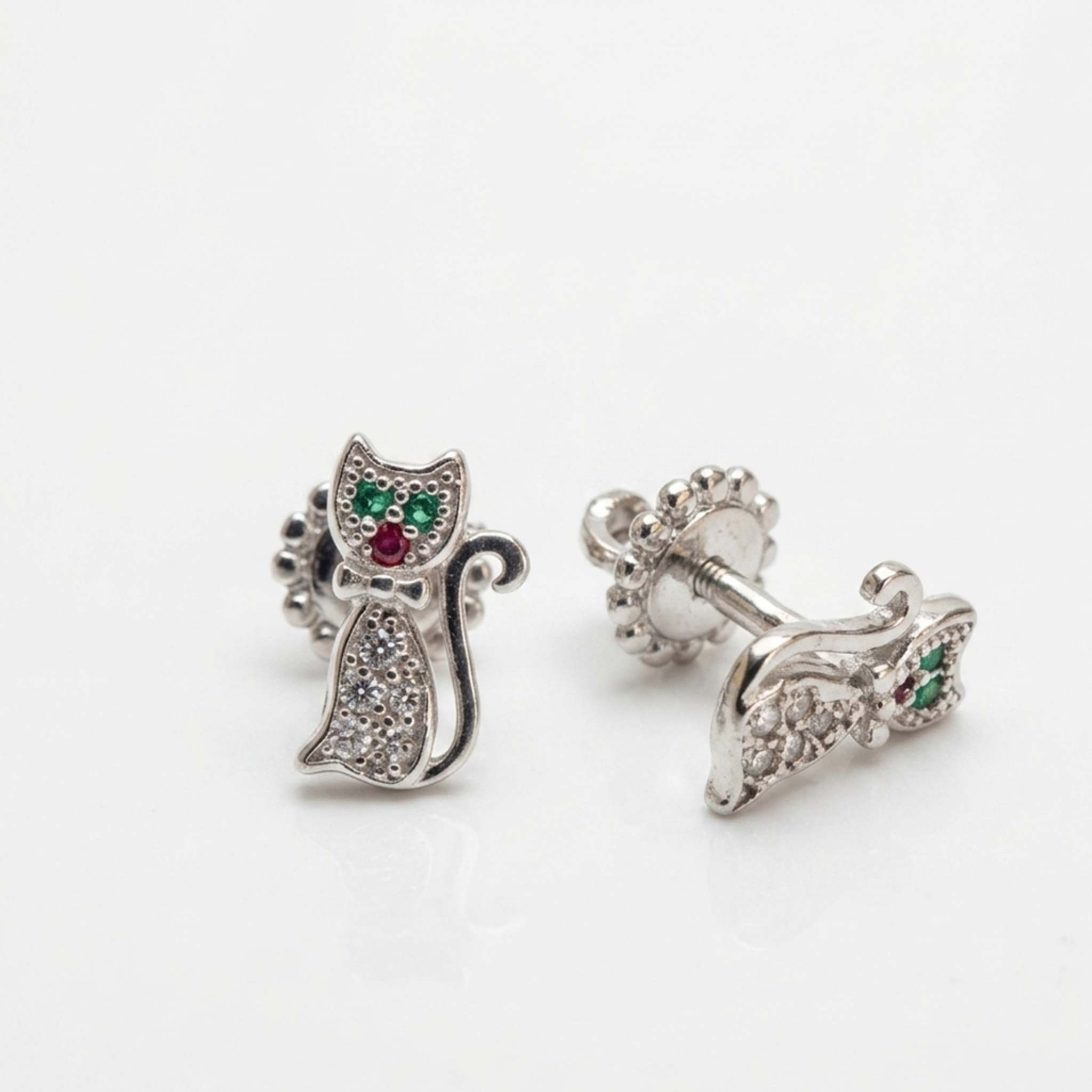 Nahaufnahme von Echtsilber Ohrsteckern im Katzen-Design mit rotem und grünem Zirkonia-Stein.