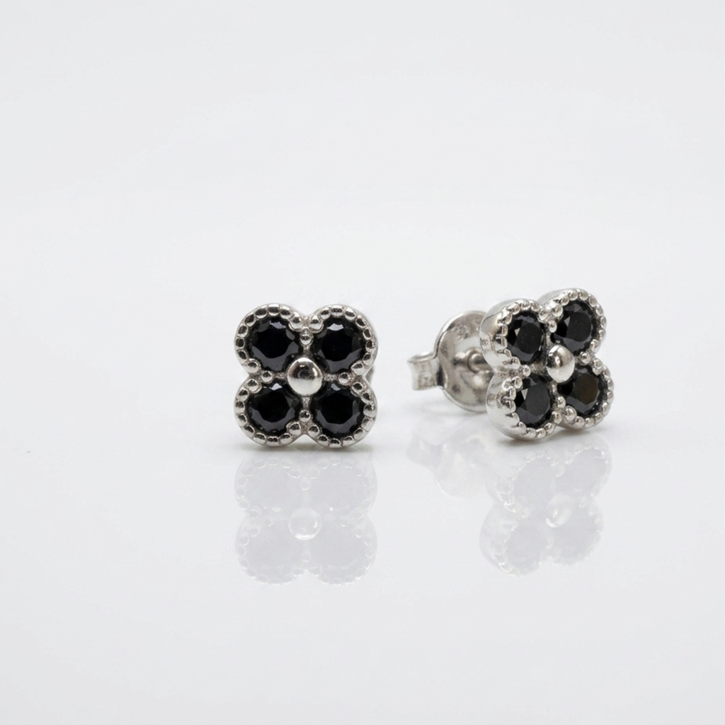 Eleganter Schmuck aus Silber 925 rhodiniert, kleine dezente Kleeblatt-Ohrstecker mit schwarzen Zirkonia und sicherem Schraubverschluss auf weißem Grund.
