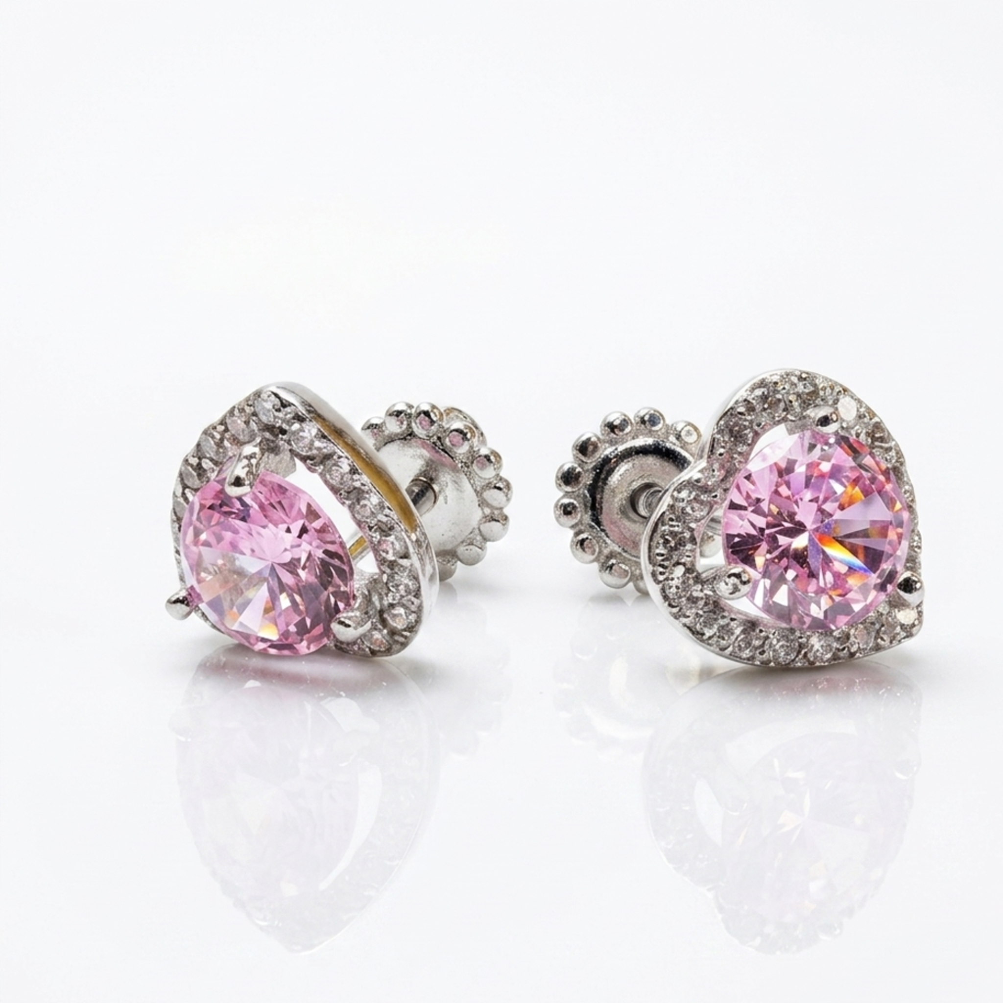 Ohrstecker in Herzform aus Silber 925 mit einem rosa Zirkonia и weißer Entourage. Modell mit sicherem Schraubverschluss und rhodinierter Oberfläche auf weißem Hintergrund.