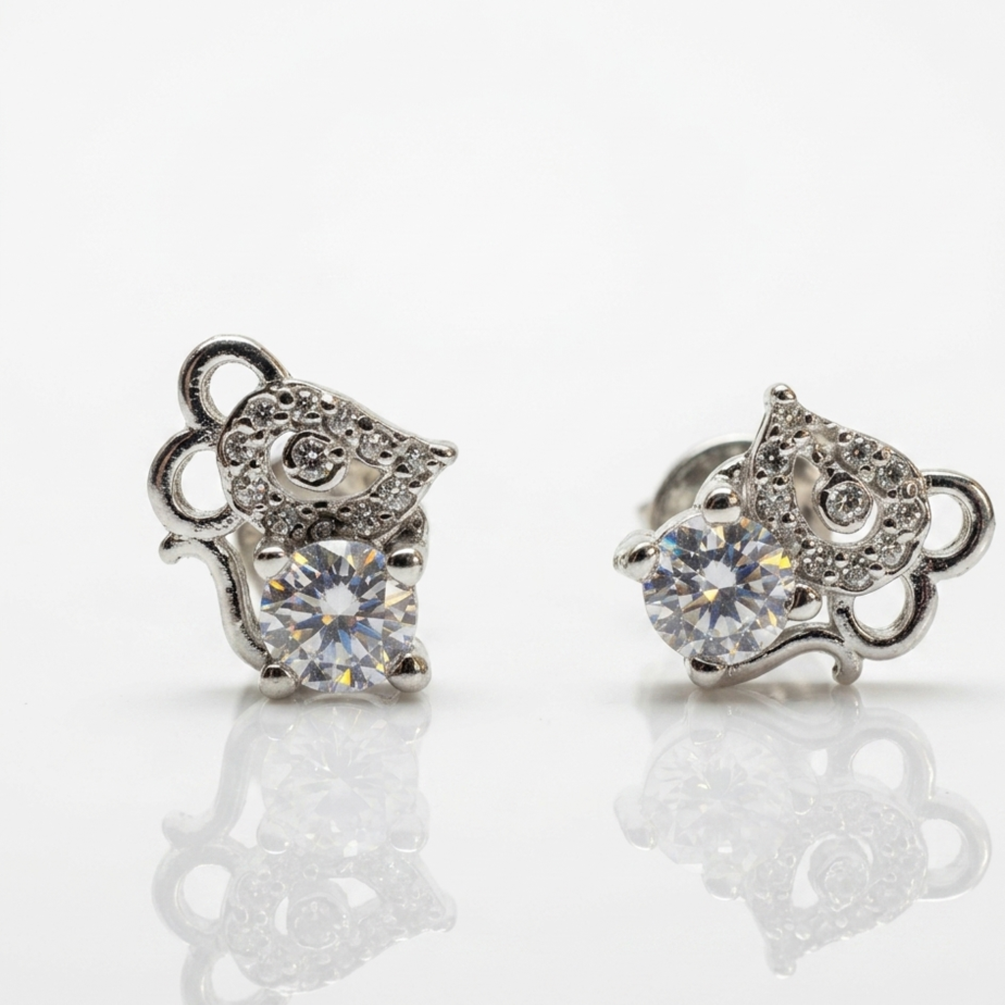 Nahaufnahme von filigranen Ohrringen aus Sterlingsilber 925, das tierische Maus-Motiv komplett mit weißen Zirkonia-Steinen besetzt, freigestellt auf weißem Boden.
