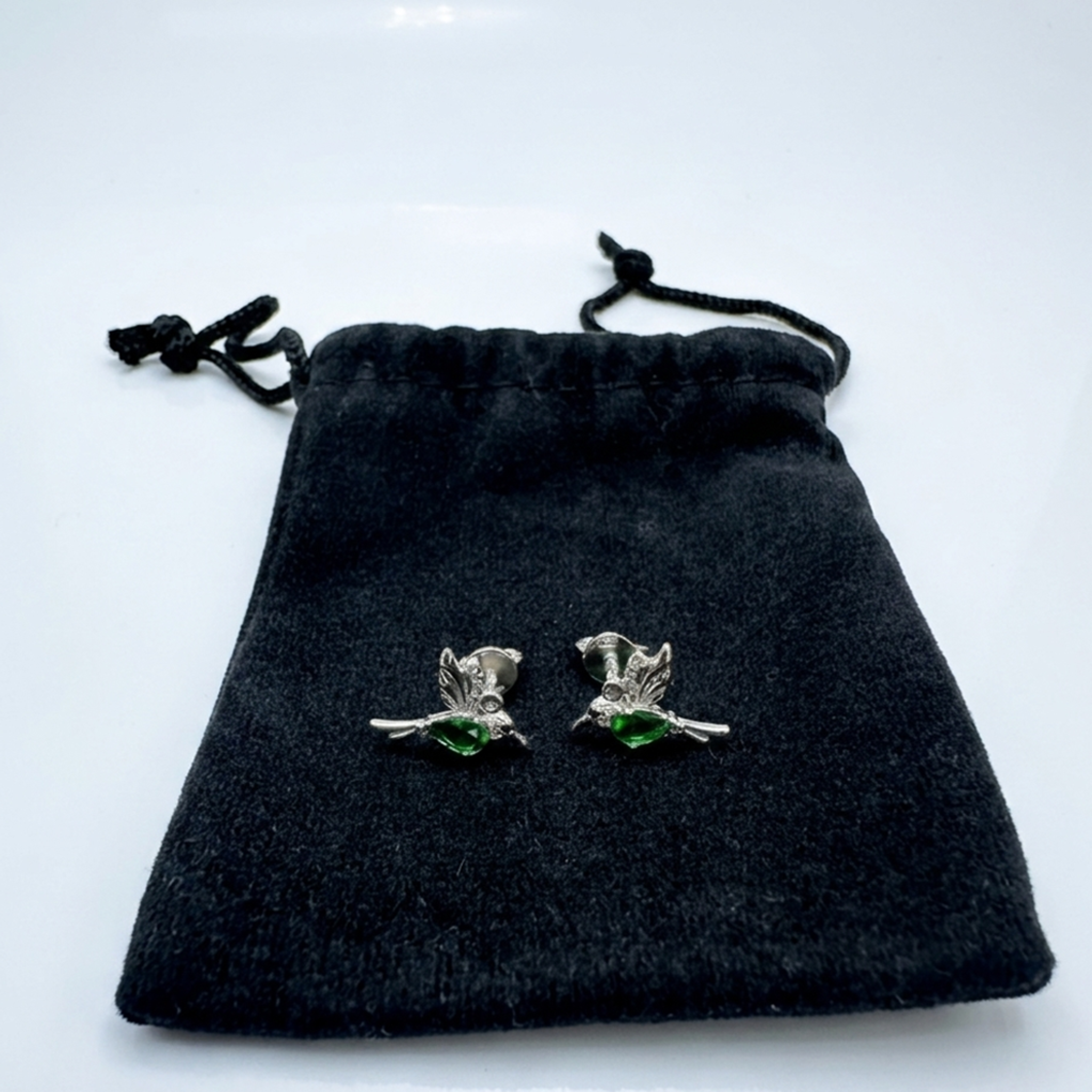 Lieferung: Hochwertige Motiv-Ohrringe aus 925er Sterling Silber mit Rhodium-Beschichtung und grünem Zirkonia-Besatz, geliefert in dem abgebildeten schwarzen Samtbeutel.