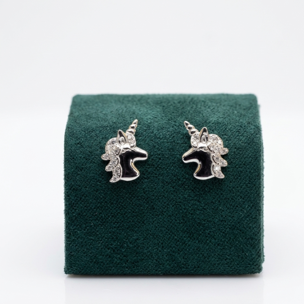 Nahaufnahme der luxuriösen Einhorn-Ohrringe aus 925er Sterling Silber mit Rhodium-Anlaufschutz und glitzernder Mähne auf einem edlen grünen Samtaufsteller.