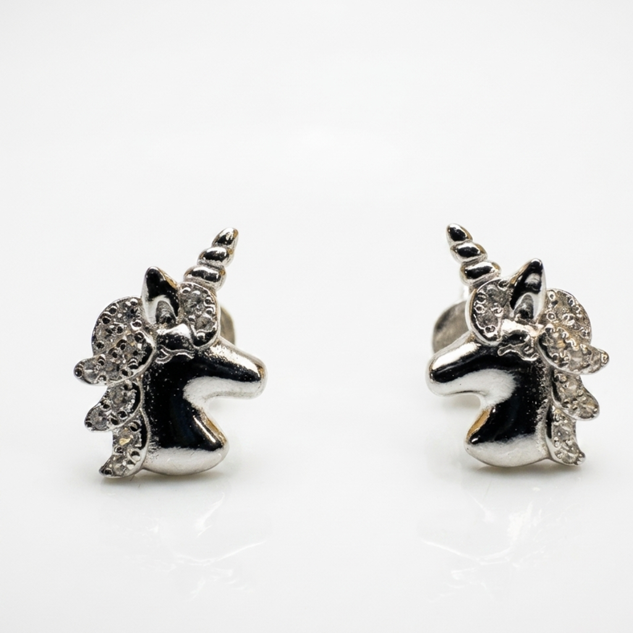 Nahaufnahme von Einhorn-Ohrsteckern aus 925er Sterling Silber, rhodiniert, mit klaren Zirkonia-Steinen auf weißem Hintergrund.