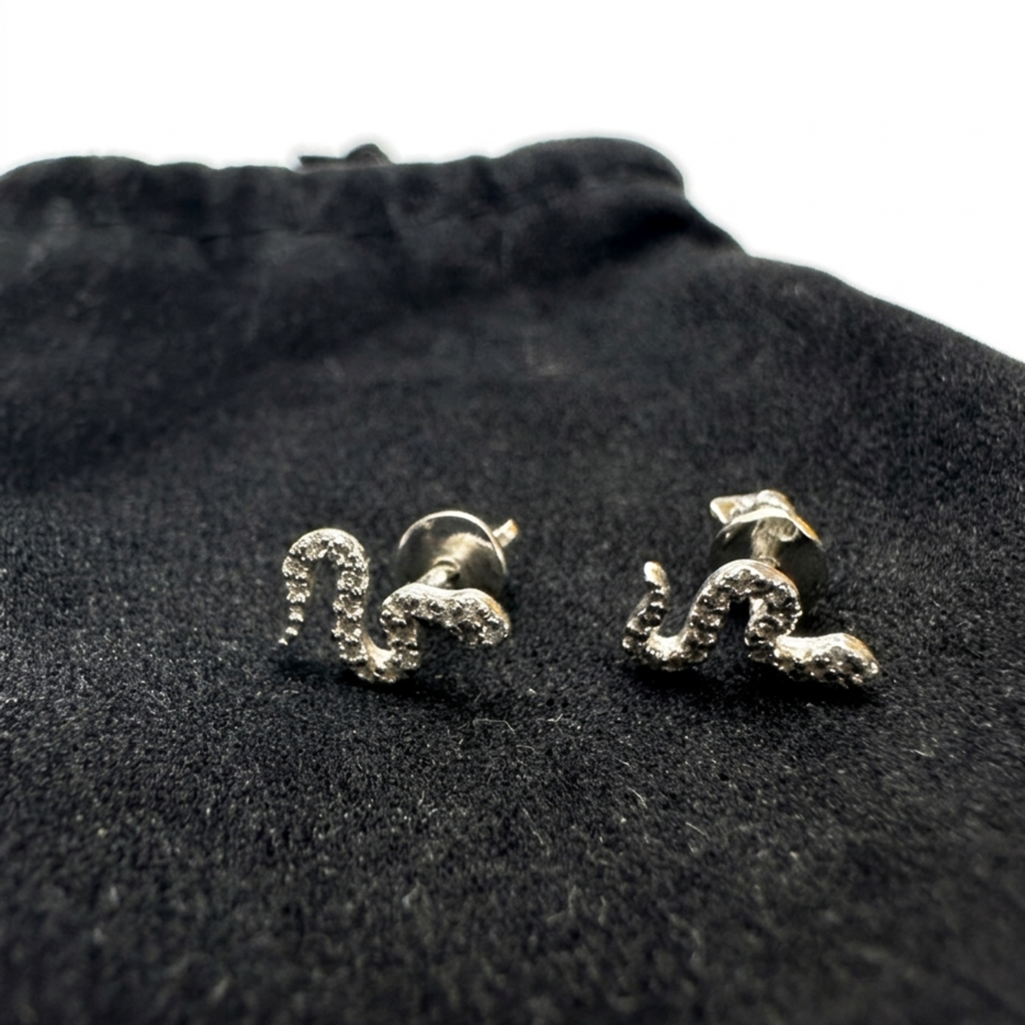 Lieferumfang: Rhodinierte Silber-Ohrstecker „Schlange“ mit weißen Zirkonia aus 925 Sterling Silber mit passendem Schmuckbeutel aus Samt.