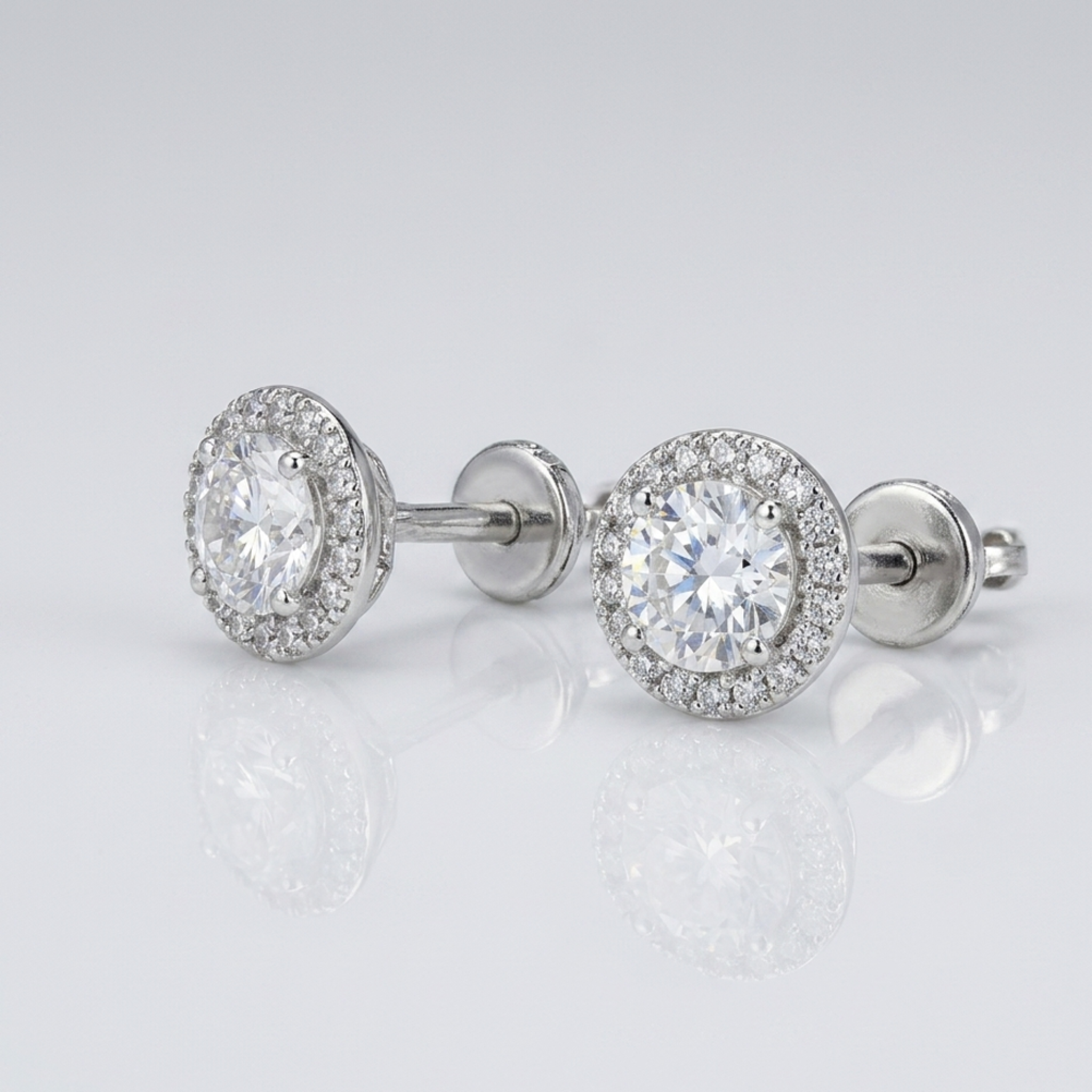 Detailansicht von 925 Silber-Ohrringen mit rundem Zirkonia-Zentralstein und feinem Pavé-Besatz auf hellem Studiohintergrund.