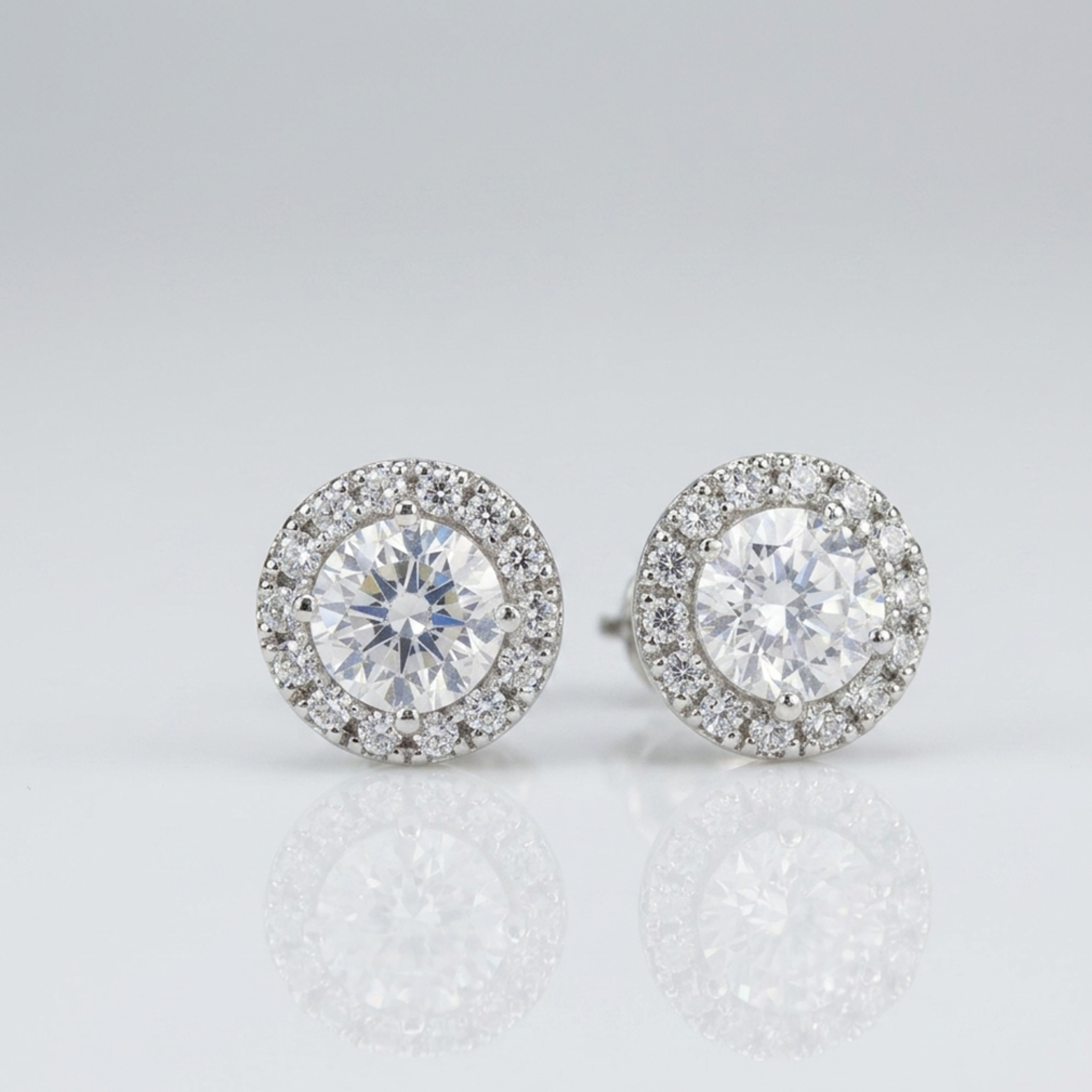 Nahaufnahme von eleganten runden Damen-Ohrringen aus rhodiniertem Silber mit glitzerndem Zirkonia-Besatz.