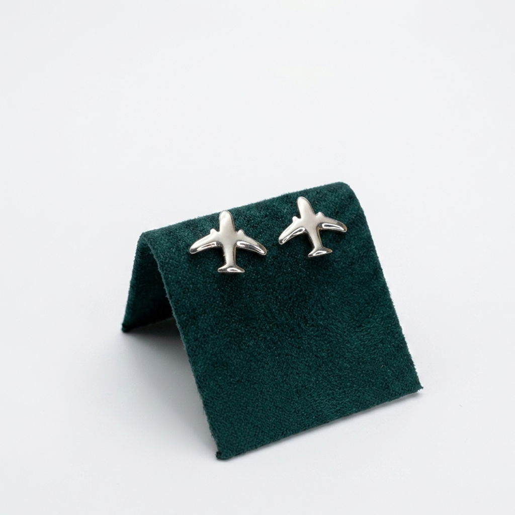Originelle Flugzeug-Ohrstecker aus 925er Silber, rhodiniert, im minimalistischen Design, elegant präsentiert auf einem dunkelgrünen Samt-Display.