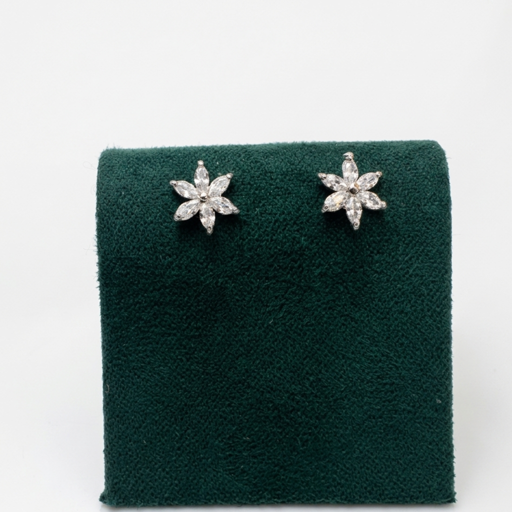 Nahaufnahme der Vorderansicht von filigranen Blüten-Ohrringen mit klaren Zirkonia im Marquise-Schliff auf einem edlen grünen Samtaufsteller.