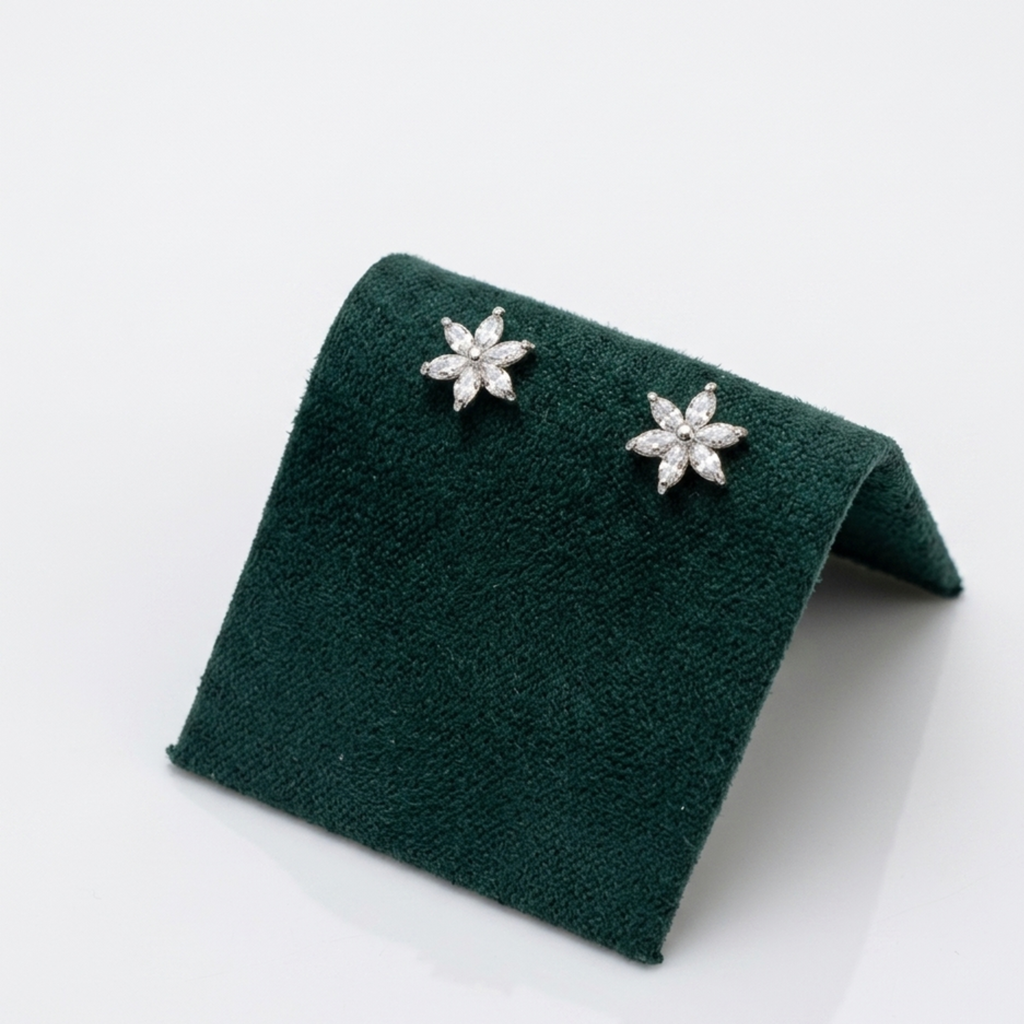 Elegante Blumen-Ohrstecker aus 925er Silber, rhodiniert, mit funkelnden Zirkonia, elegant präsentiert auf einem dunkelgrünen Samt-Display.
