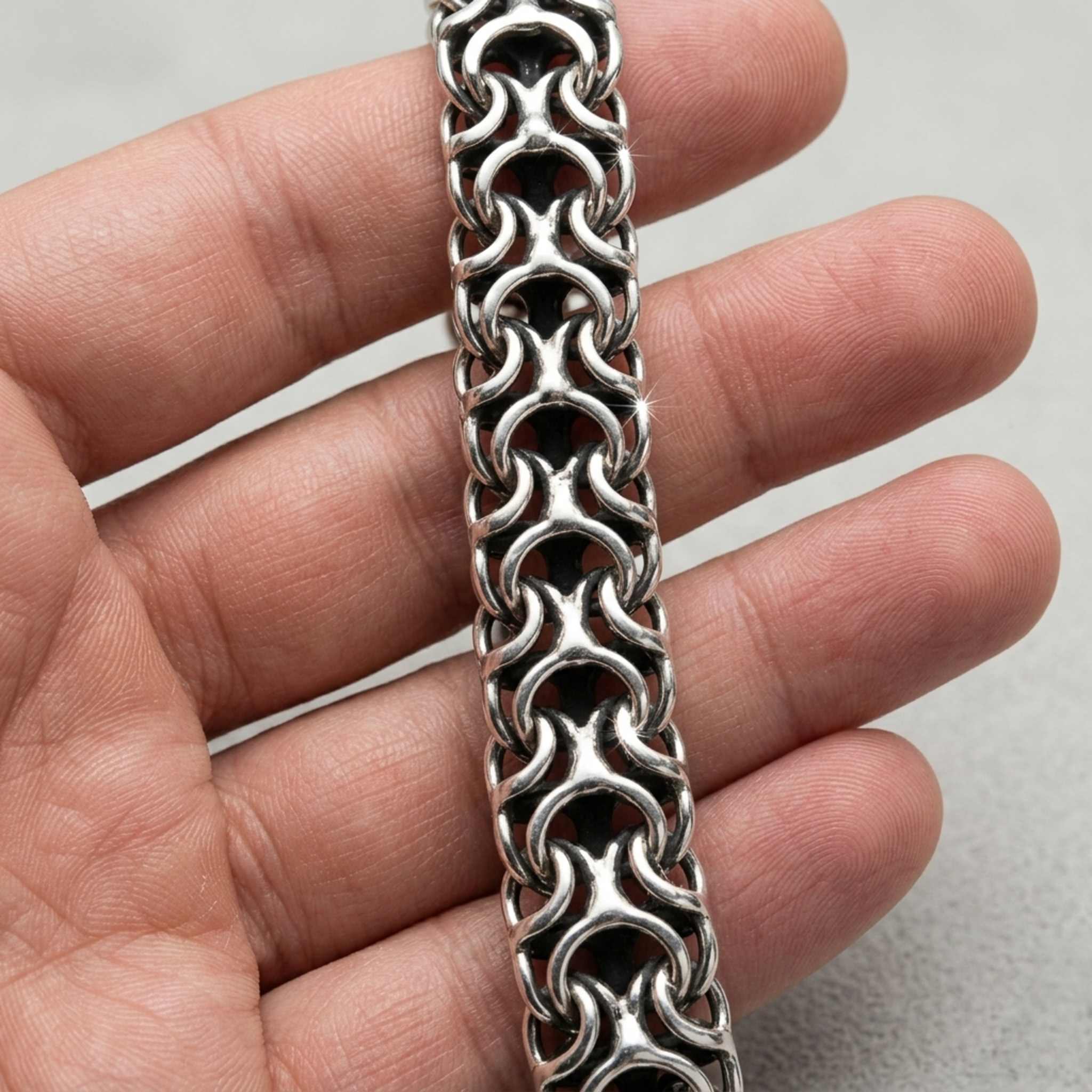 Tragebeispiel der massiven Silberkette Modell Ramses aus 925er Silber mit oxidierter Oberfläche auf der Hand zur Demonstration des detailreichen Geflechts.