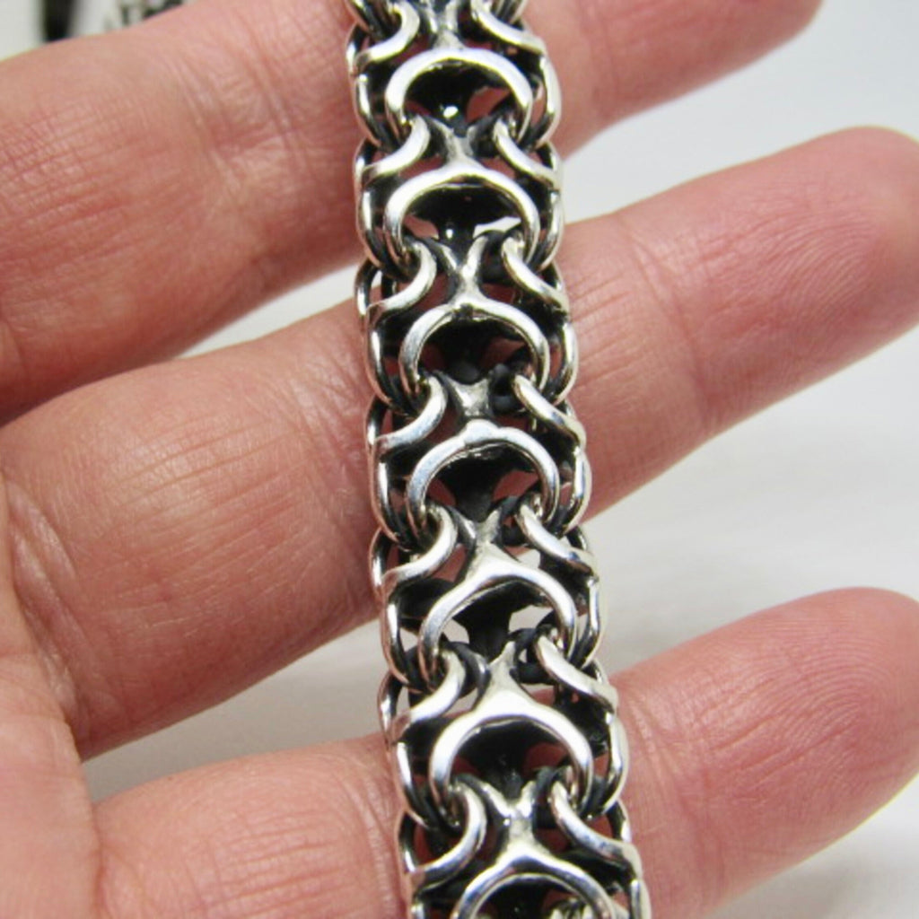 Tragebeispiel der massiven Silberkette Modell Ramses aus 925er Silber mit oxidierter Oberfläche auf der Hand zur Demonstration des detailreichen Geflechts.