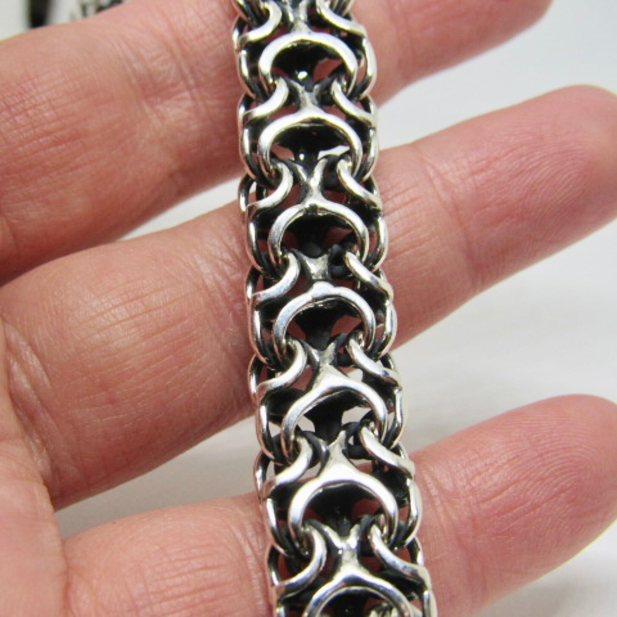 Tragebeispiel der massiven Silberkette Modell Ramses aus 925er Silber mit oxidierter Oberfläche auf der Hand zur Demonstration des detailreichen Geflechts.