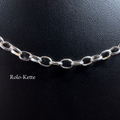 Nahaufnahme einer filigranen Rolo-Kette aus glänzendem 925er Silber auf schwarzem Lederhintergrund mit dem Schriftzug Rolo-Kette.