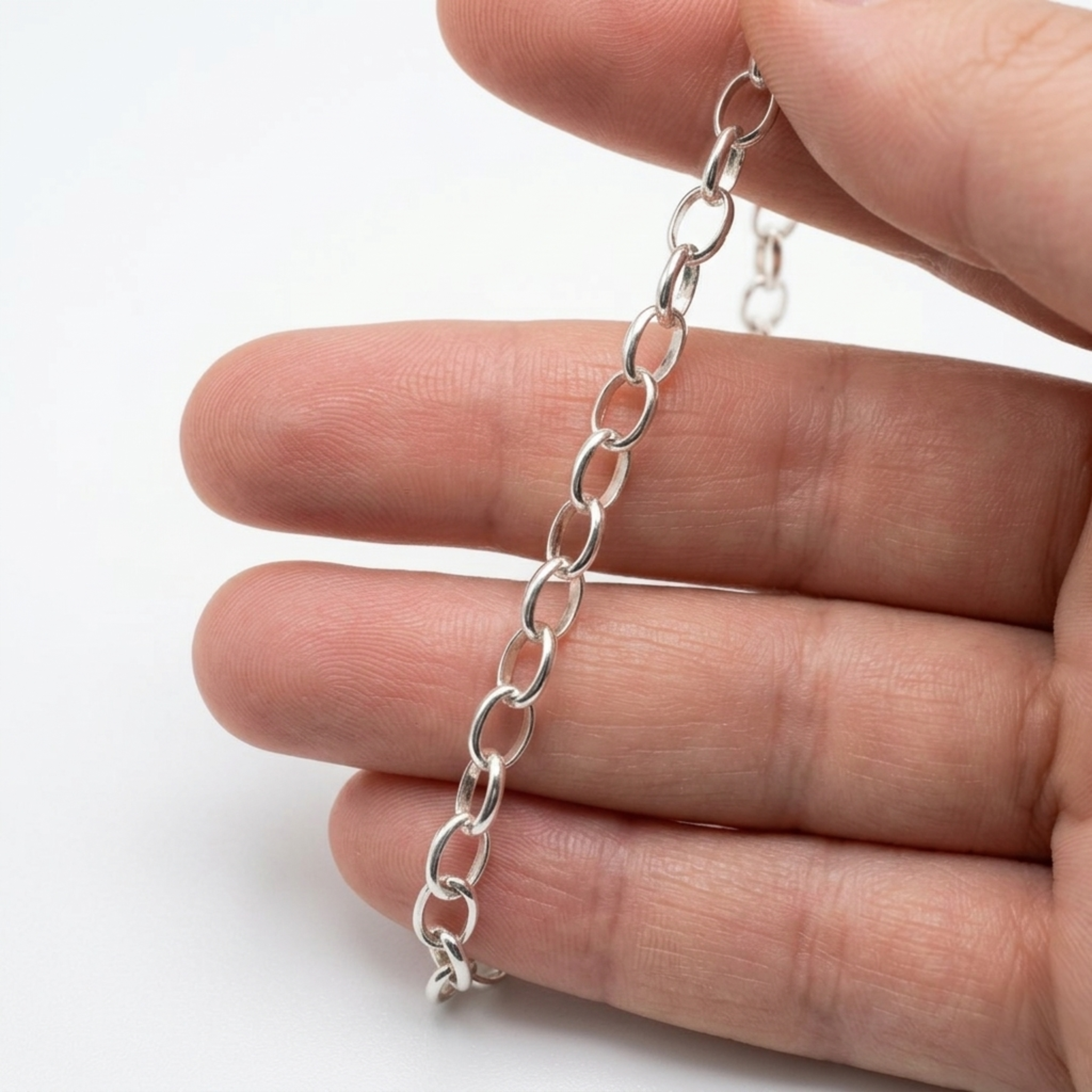 Detailansicht einer handgefertigten Rolo-Gliederkette aus Silber 925, на куске текста: auf den Fingern präsentiert.