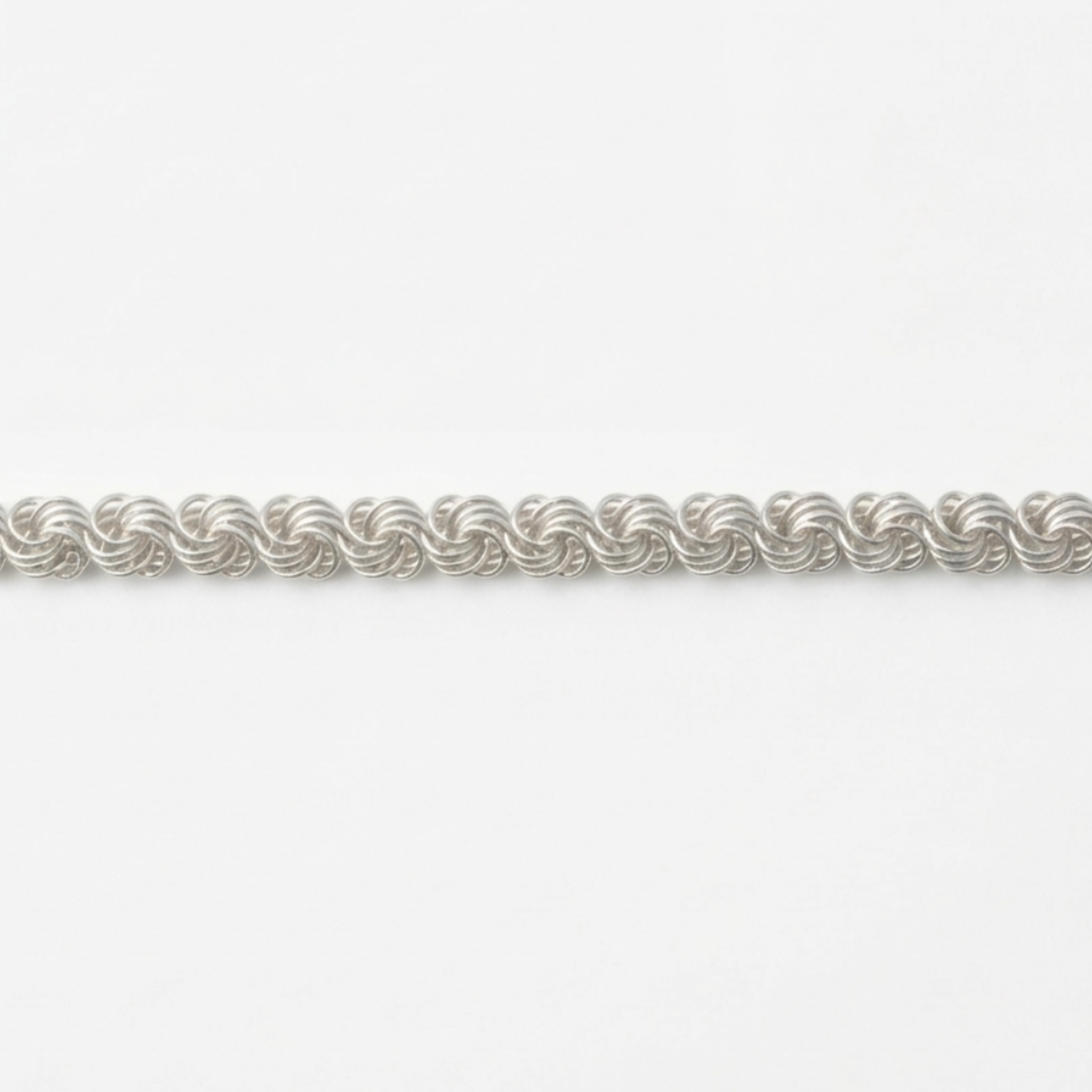 Nahaufnahme einer handgefertigten Silberkette Modell Rose aus 925er Sterling Silber, präsentiert auf einem hellen Hintergrund.