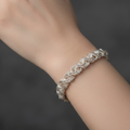 Detailansicht eines handgefertigten Damenarmbands Modell Rose aus 925er Silber an einem Handgelenk vor dunklem Hintergrund.