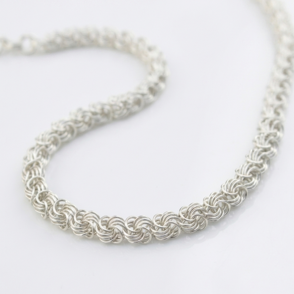 Handgefertigte Silberkette Modell Rose aus 925er Sterling Silber, elegant geschwungen präsentiert auf hellem Hintergrund.