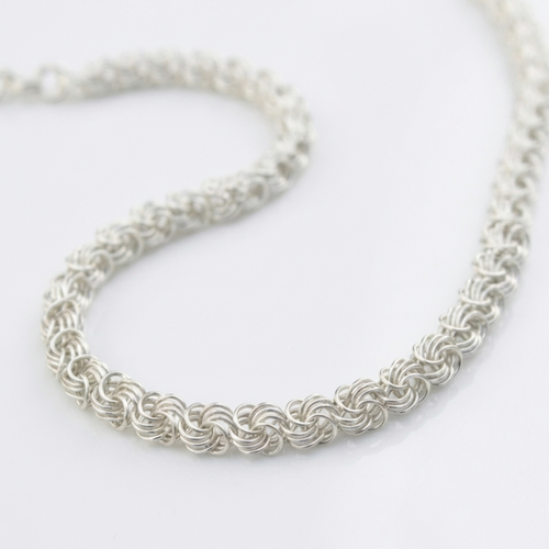 Handgefertigte Silberkette Modell Rose aus 925er Sterling Silber, elegant geschwungen präsentiert auf hellem Hintergrund.