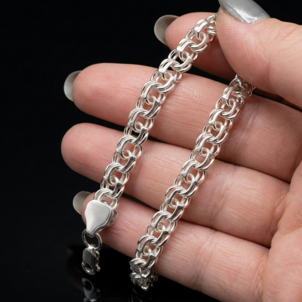 Hand gefaltetes Armband aus 925er Sterlingsilber im Bismarck-Stil mit sichtbarem Karabinerverschluss gehalten von einer Hand.