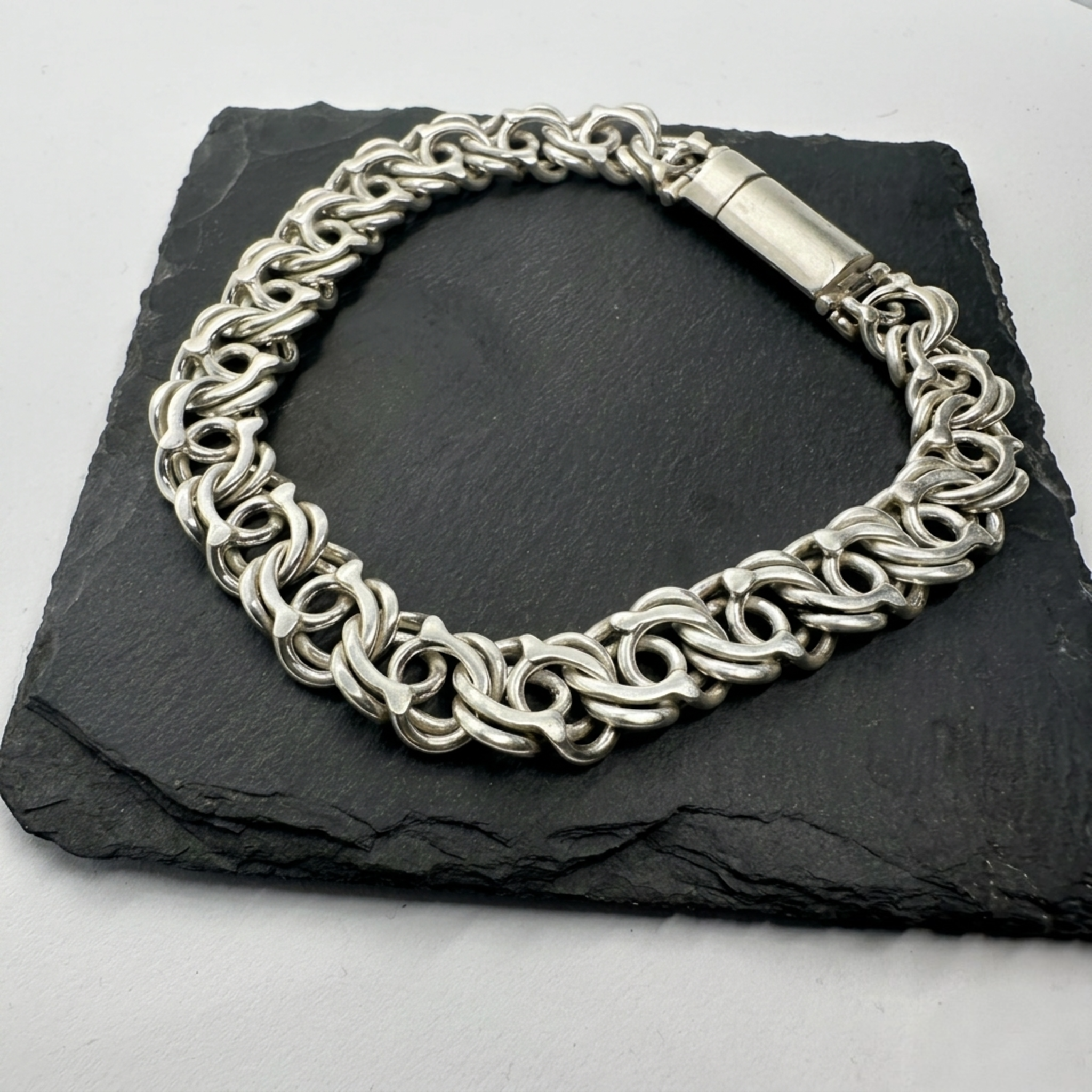 Handgefertigtes Werwolf-Silberarmband aus 925 Sterling Silber mit einem massiven und sicheren Zylinder-Steckverschluss auf einem schwarzen Stein.